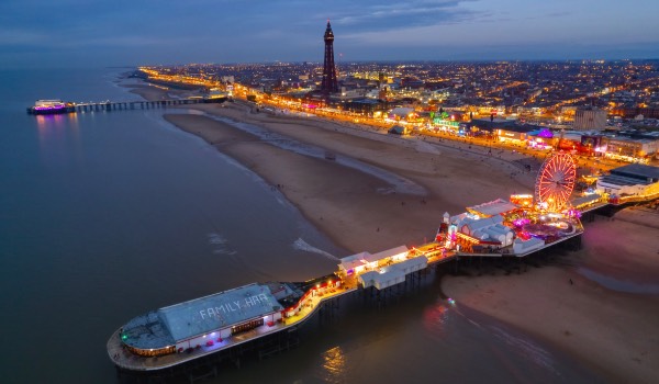An aerial photo of Blackpool showing the tower, promenade and pier taken at dusk.