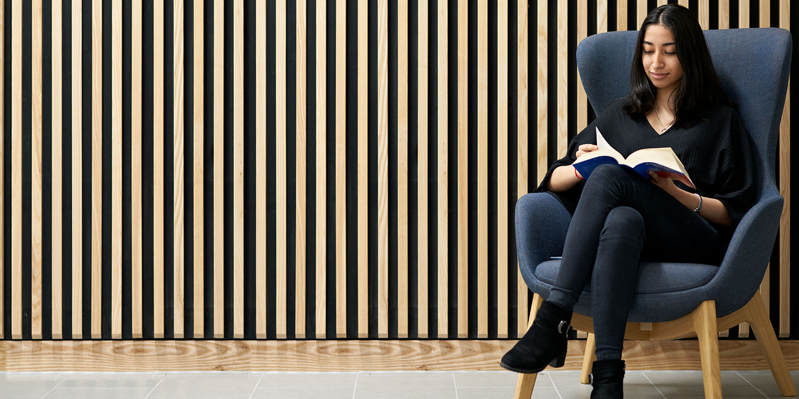 Women sitting on a chair, reading.